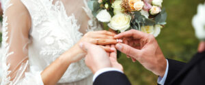a groom placing a ring on a brides finger