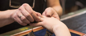 a jeweler using a ring sizer to determine someone's ring size
