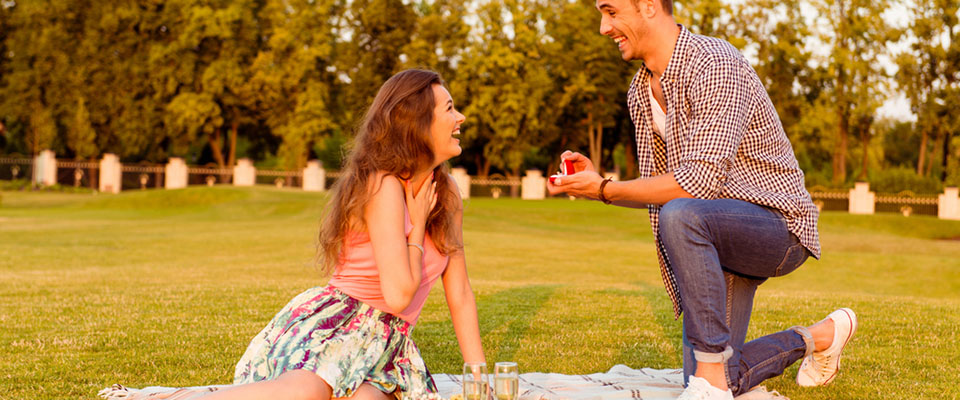man proposing in park over picnic